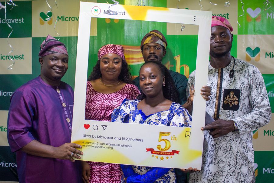 A group celebrating five years of Microvest with the anniversary frame